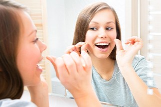 Woman flossing her teeth
